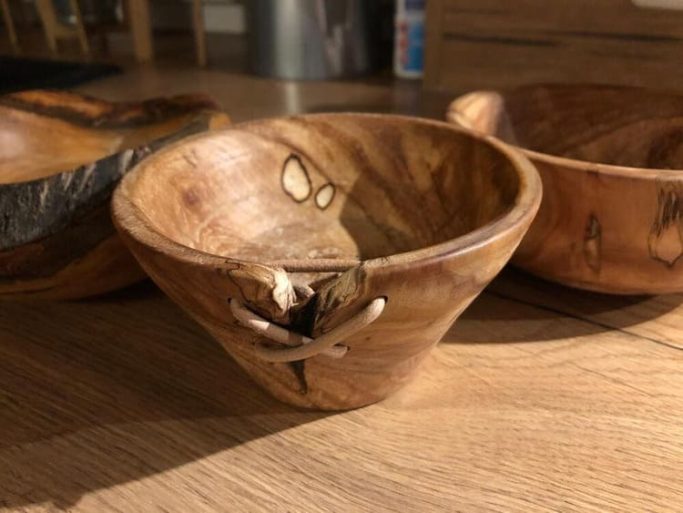 Gedrechselte Holzschale mit natürlicher Maserung und einer kleinen Rissstelle.